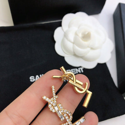 YSL 26S BAGUETTE CRYSTAL LOGO DROP EARRINGS IN GOLD TONE METAL 629136