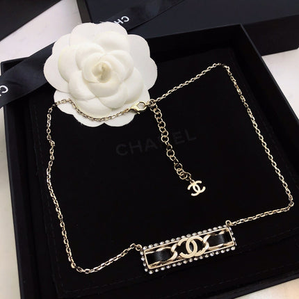 CHANEL 26S CHANEL CC LOGO CRYSTAL TRIM BAR PENDANT NECKLACE WITH BLACK LEATHER IN GOLD METAL 633315