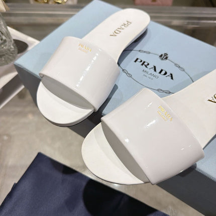 PRADA 26S LOGO EMBOSSED SLIDE SANDALS IN WHITE PATENT CALFSKIN