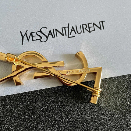 YSL 26S MONOGRAM BROOCH IN GOLD TONE METAL 630942