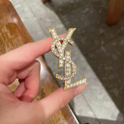 YSL 26S CRYSTAL MONOGRAM BROOCH IN GOLD TONE METAL 631043